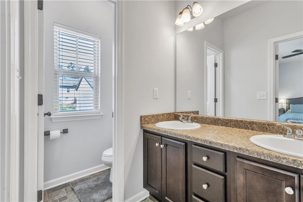 265 Valley Crossing Canton, GA 30114 - Photo 17 of 31 a bathroom with a granite countertop sink a toilet and a mirror