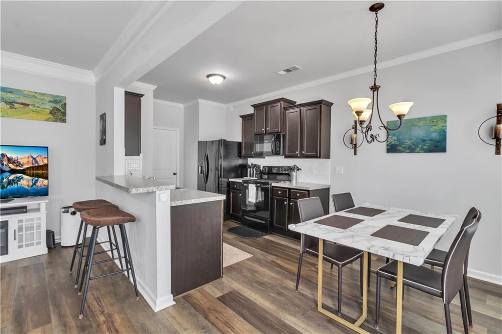 265 Valley Crossing Canton, GA 30114 - Photo 10 of 31 a kitchen with kitchen island a dining table chairs stainless steel appliances and cabinets