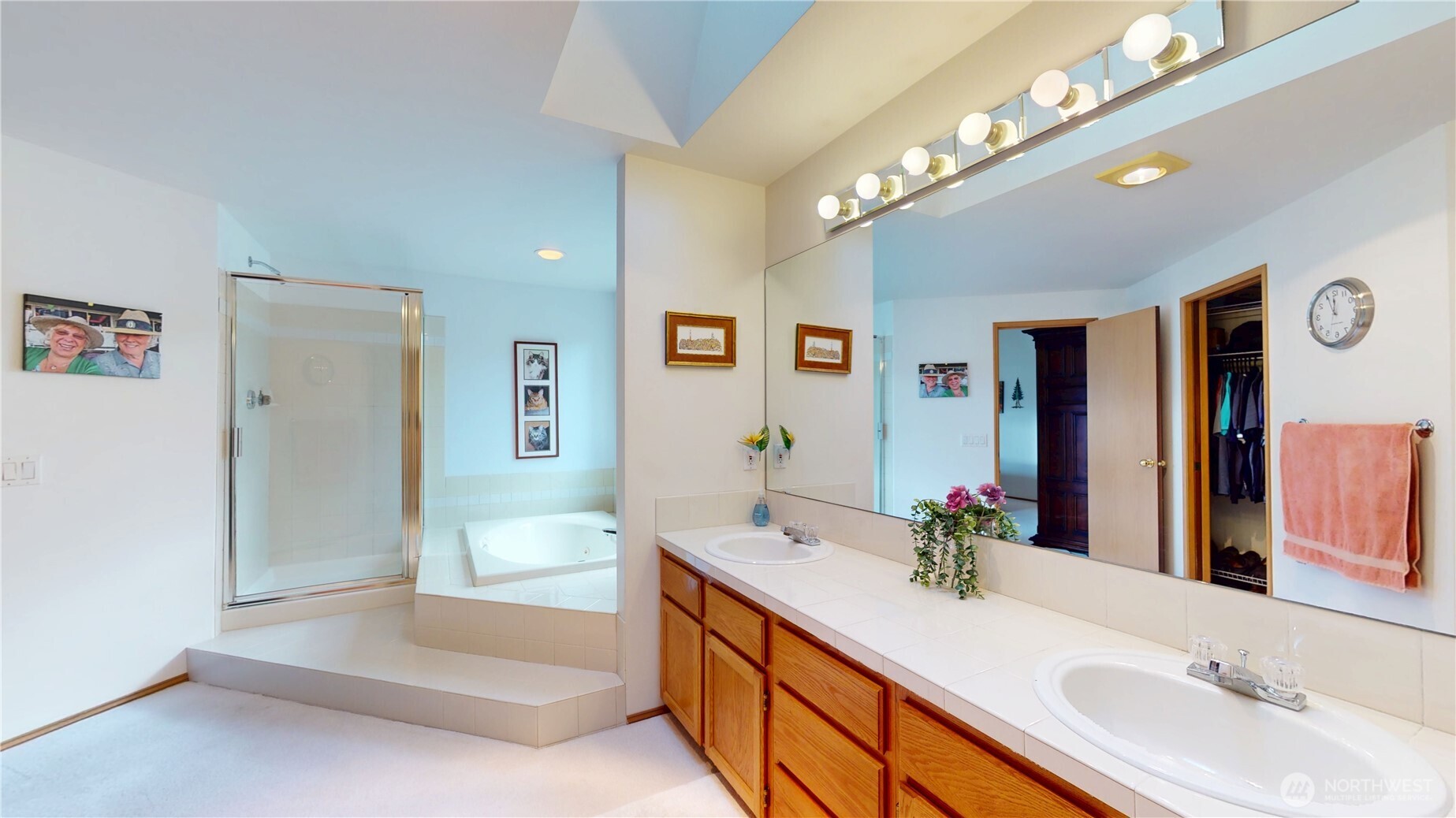 1704 Field Place Northeast Renton, WA 98059 - Photo 22 of 38 a spacious bathroom with a double vanity sink a large mirror and a bathtub