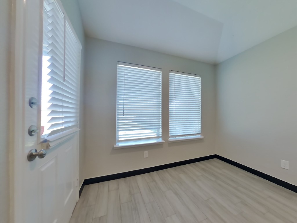 8523 Aster Glen Way Rosharon, TX 77583 - Photo 4 of 15 a view of an empty room with a window and wooden floor