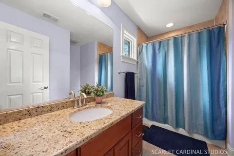 a bathroom with a granite countertop toilet a sink and a mirror