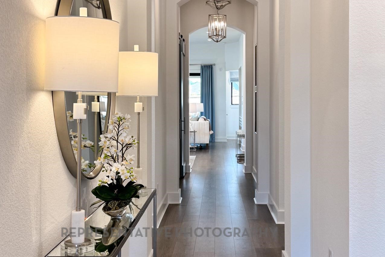 13048 Wandering Rdg Lane Conroe, TX 77302 - Photo 27 of 49 a view of a hallway with wooden floor and a chandelier