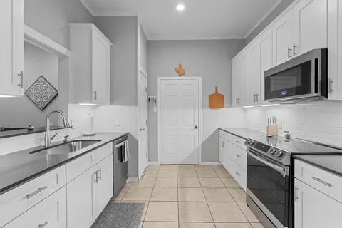 a kitchen with stainless steel appliances a stove microwave and sink