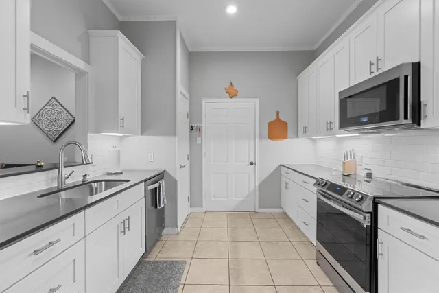 a kitchen with stainless steel appliances a stove microwave and sink