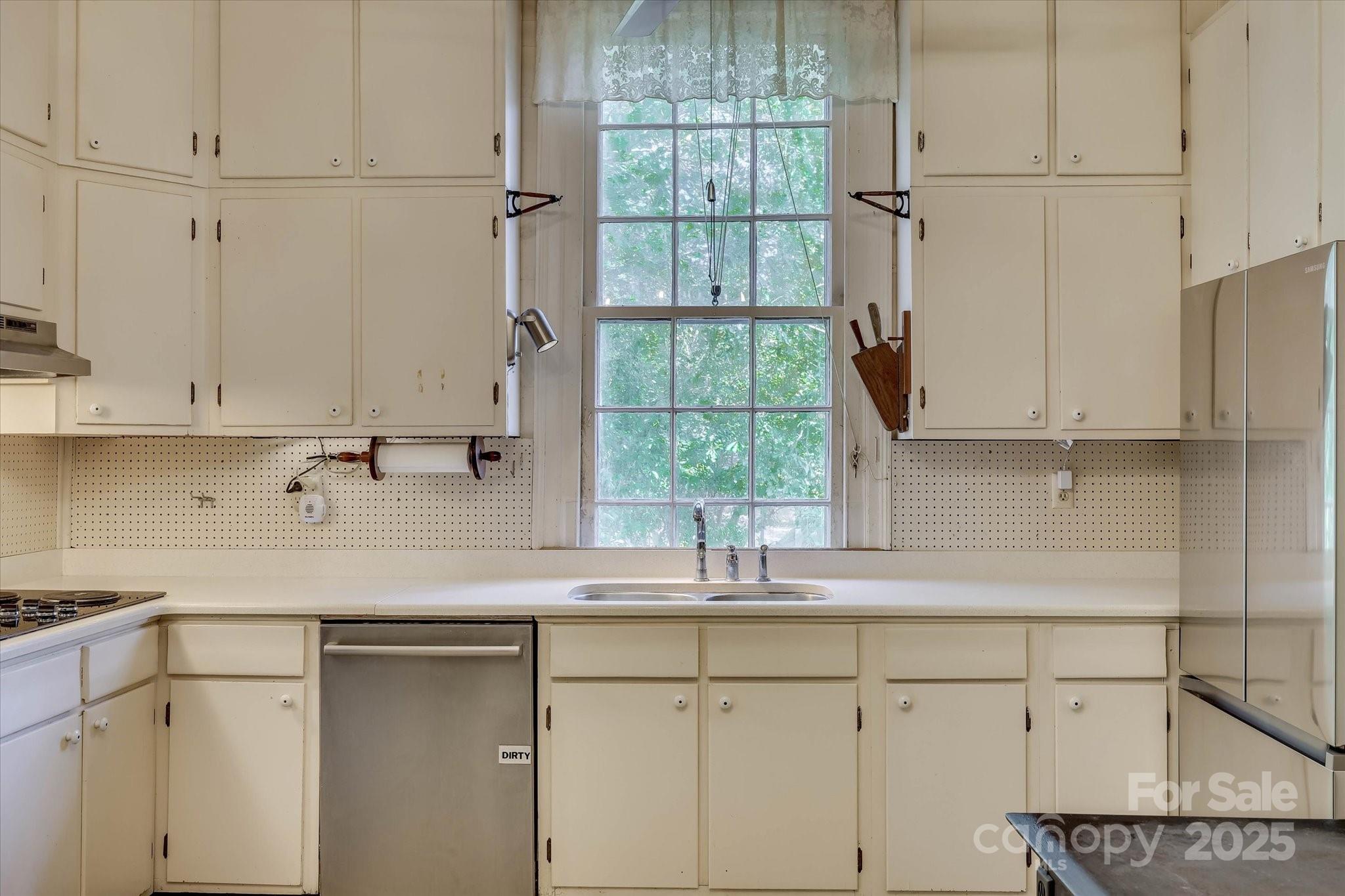 621 Meeting Street Road Edgefield, SC 29824 - Photo 13 of 40 a kitchen with stainless steel appliances white cabinets and a window