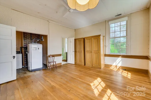 a view of a room with wooden floor and a ceiling fan