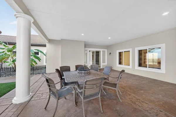 a spacious bathroom with a granite countertop sink a large mirror and a bathtub