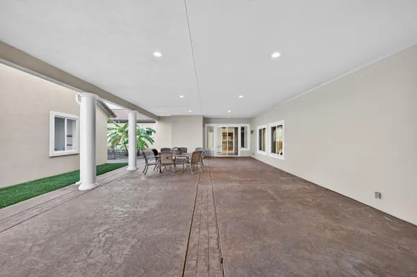 a living room with furniture large window and wooden floor