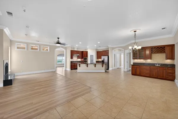 a kitchen with stainless steel appliances granite countertop a refrigerator a sink dishwasher a stove with wooden cabinets and floor