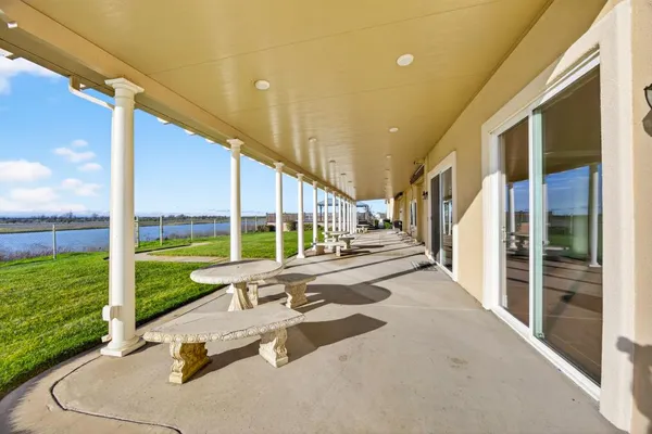 a view of a room with wooden floor chandelier and windows