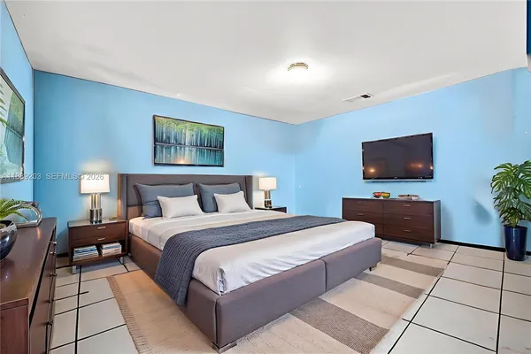 a bedroom with a bed and a flat screen tv