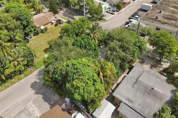 an aerial view of residential house with outdoor space and trees all around