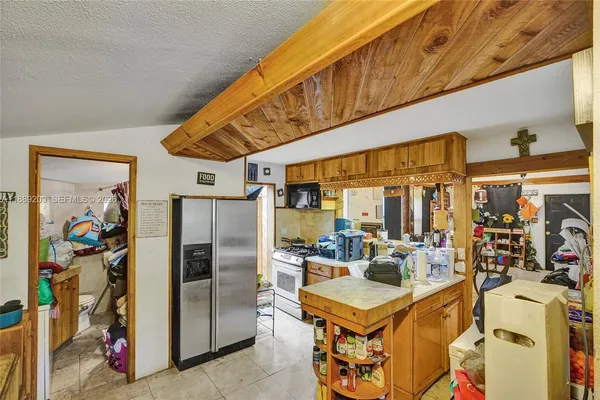 a kitchen with stainless steel appliances granite countertop a refrigerator a oven a sink and blue cabinets