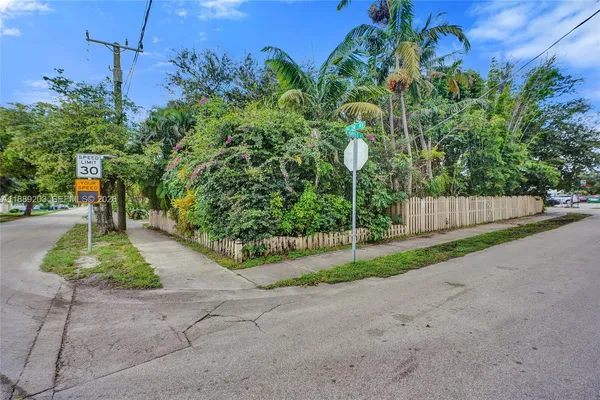 a view of a yard with wooden fence