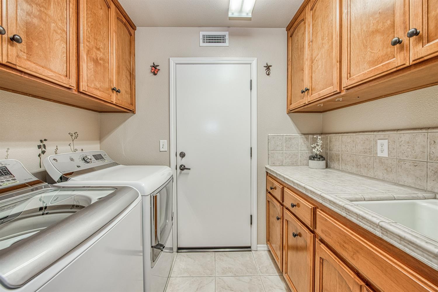 2815 Isabel Avenue Clovis, CA 93611 - Photo 17 of 31 Laundry room w/garage access, upper and lower cabinets and a utility sink.