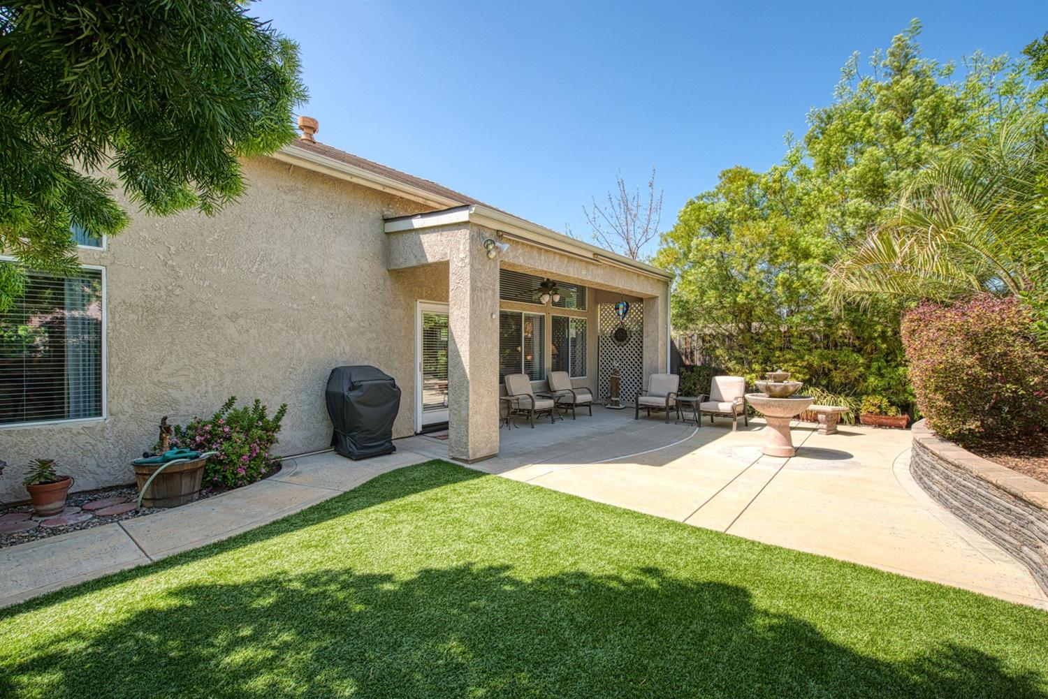 2815 Isabel Avenue Clovis, CA 93611 - Photo 28 of 31 Spacious backyard w/block fence, stone wall, synthetic lawn, and a covered patio.