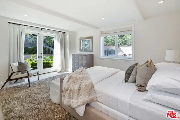 a bedroom with a bed and a large window