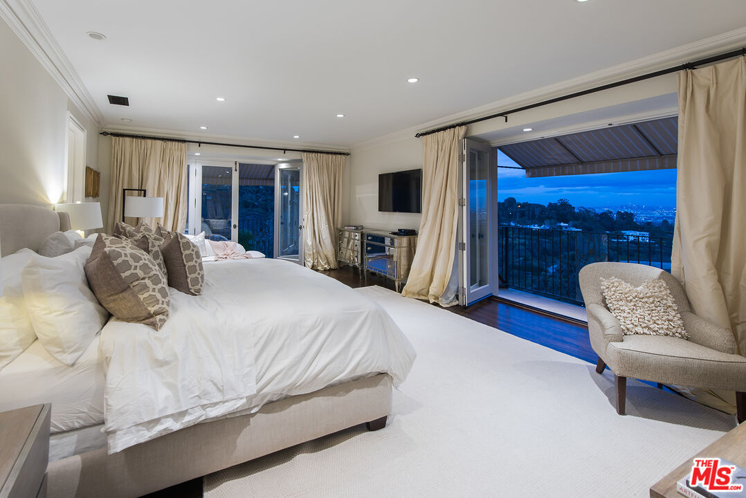 980 Stradella Road Los Angeles, CA 90077 - Photo 37 of 40 a bedroom with a bed couch and a large window