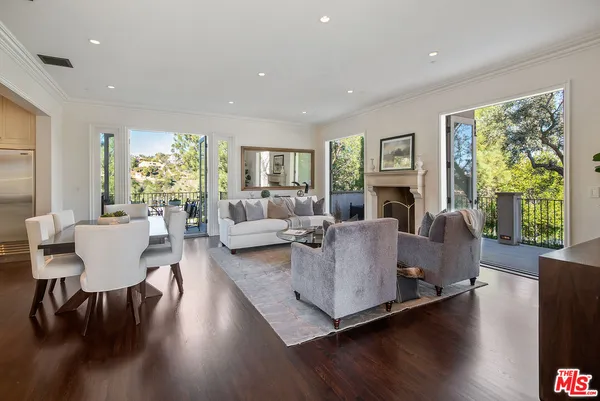 a living room with fireplace furniture and a large window