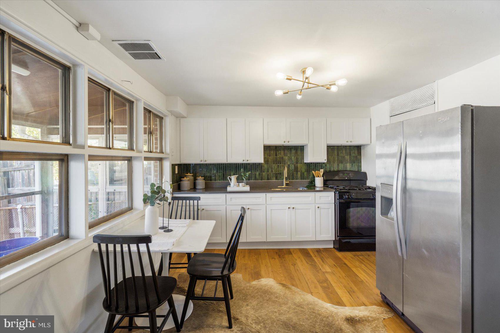 4430 Annapolis Road Halethorpe, MD 21227 - Photo 8 of 23 a kitchen with refrigerator cabinets dining table and chairs