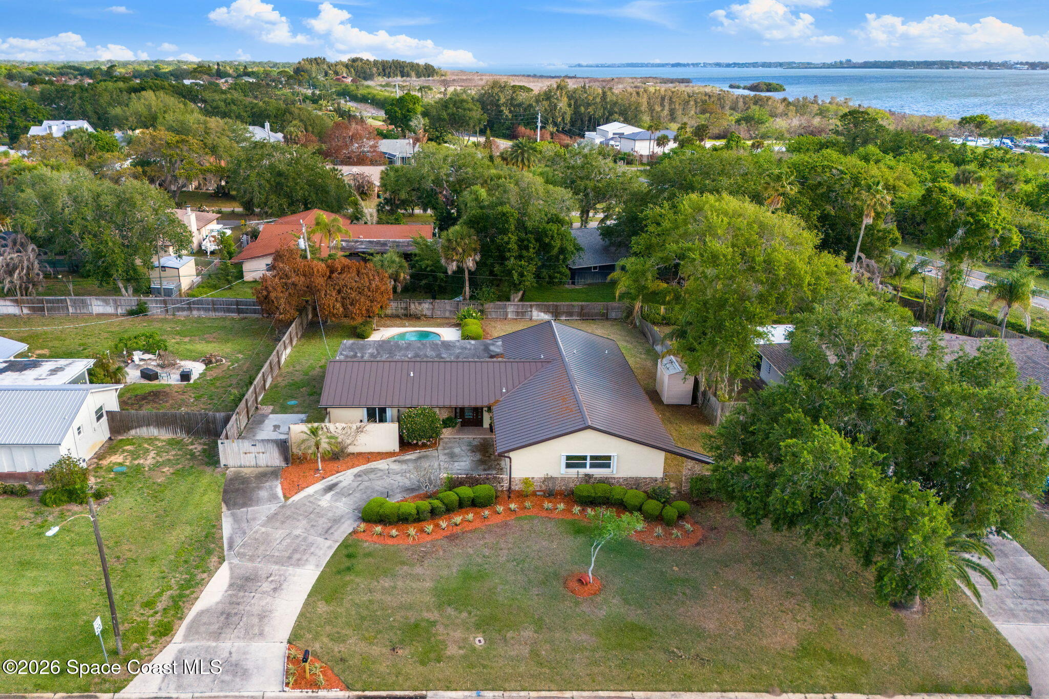 1310 St George Road Merritt Island, FL 32952 - Photo 53 of 59 an aerial view of a house with a garden and lake view