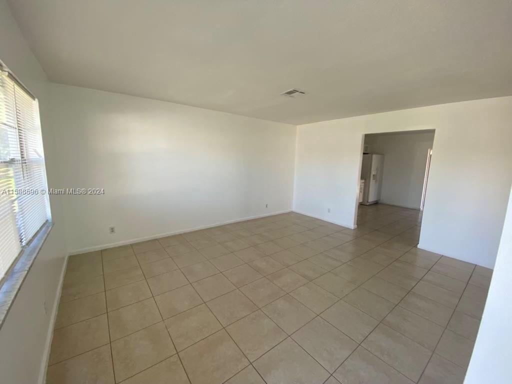 641 Silver Beach Road Riviera Beach, FL 33403 - Photo 12 of 13 wooden floor in an empty room with a window