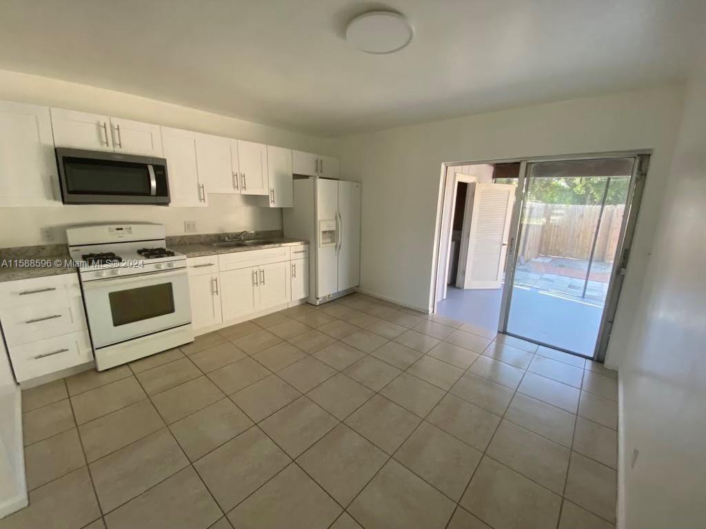 641 Silver Beach Road Riviera Beach, FL 33403 - Photo 2 of 13 a kitchen with stainless steel appliances granite countertop a stove a sink and a refrigerator