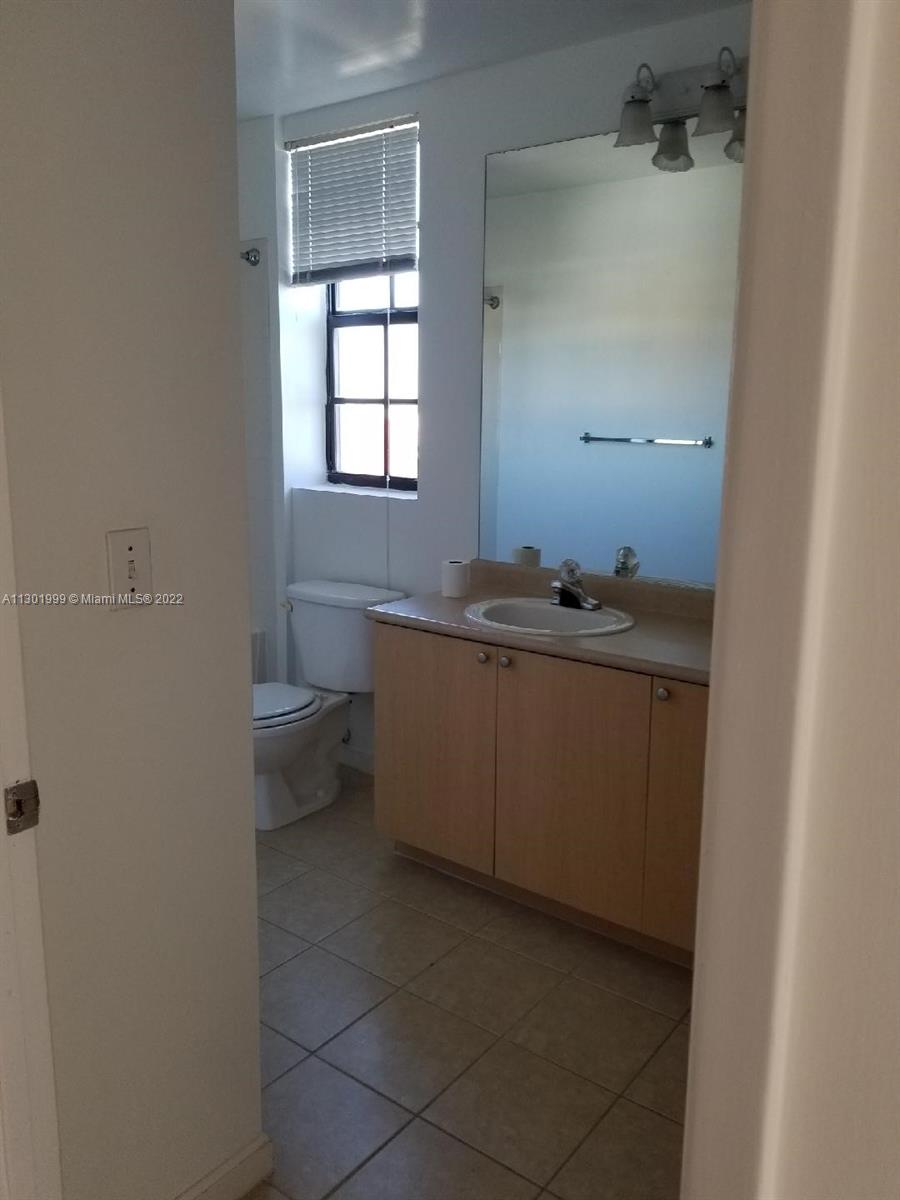 Parkside Hollywood, FL 33020 - Photo 7 of 26 a bathroom with a granite countertop sink a toilet and a window
