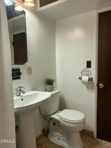 a bathroom with a sink a toilet and mirror