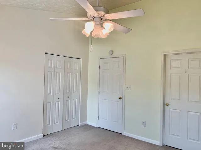 an empty room with a chandelier fan