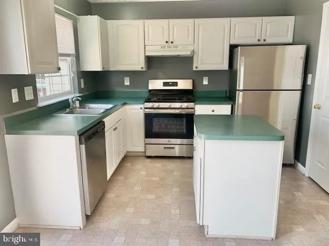 a kitchen with a refrigerator sink and stove