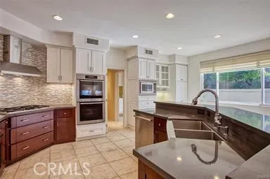 a kitchen with granite countertop a sink stainless steel appliances and cabinets