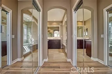a view of a hallway with wooden floor and a livingroom