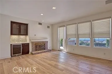 an empty room with windows and fireplace