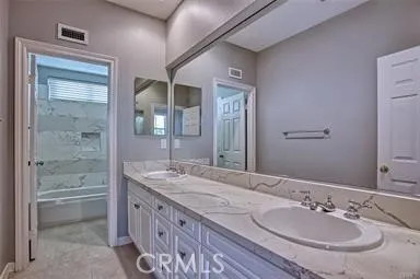 a bathroom with a granite countertop sink a mirror and a shower