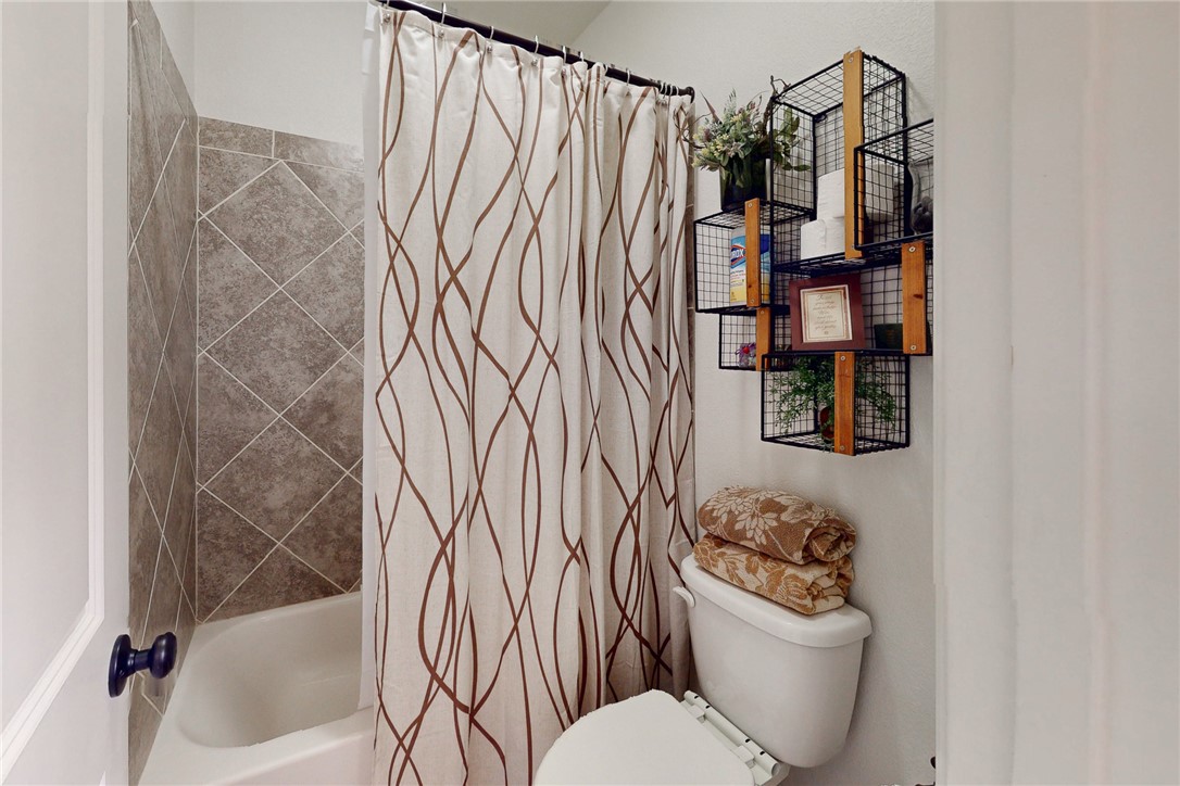 3317 Fiddlers Green Bryan, TX 77808 - Photo 23 of 36 a bathroom with a toilet and a shower curtain