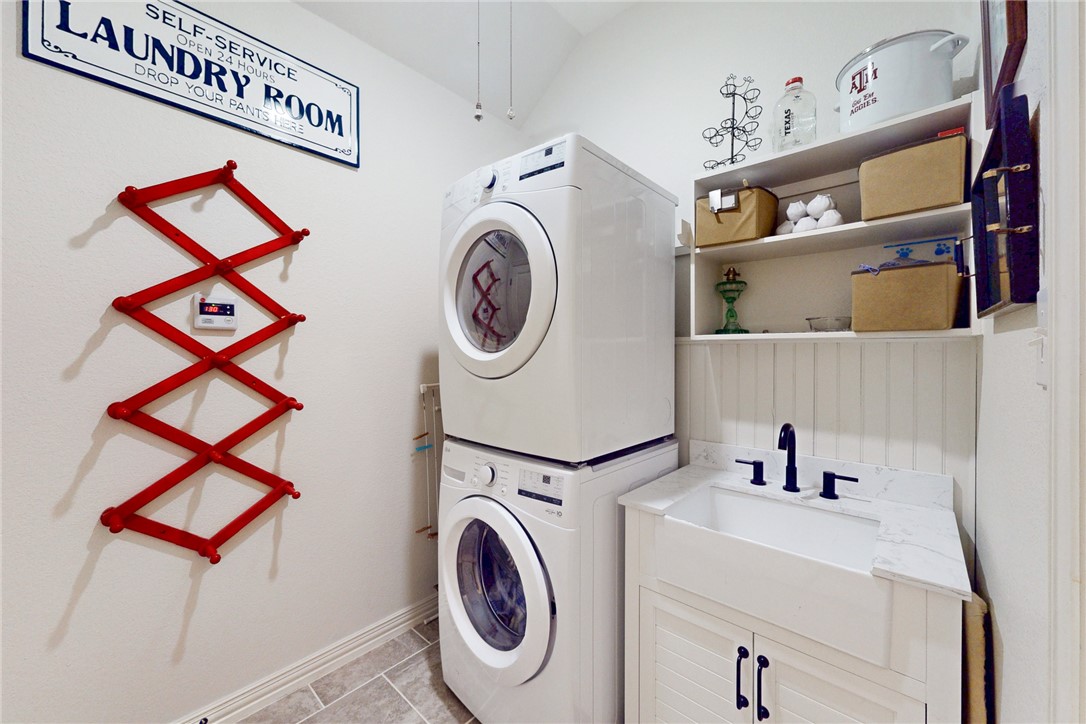 3317 Fiddlers Green Bryan, TX 77808 - Photo 34 of 36 Utility Room with Front Load Stackable Washer and Dryer and Full Sink with Cabinet and Shelves for Storage