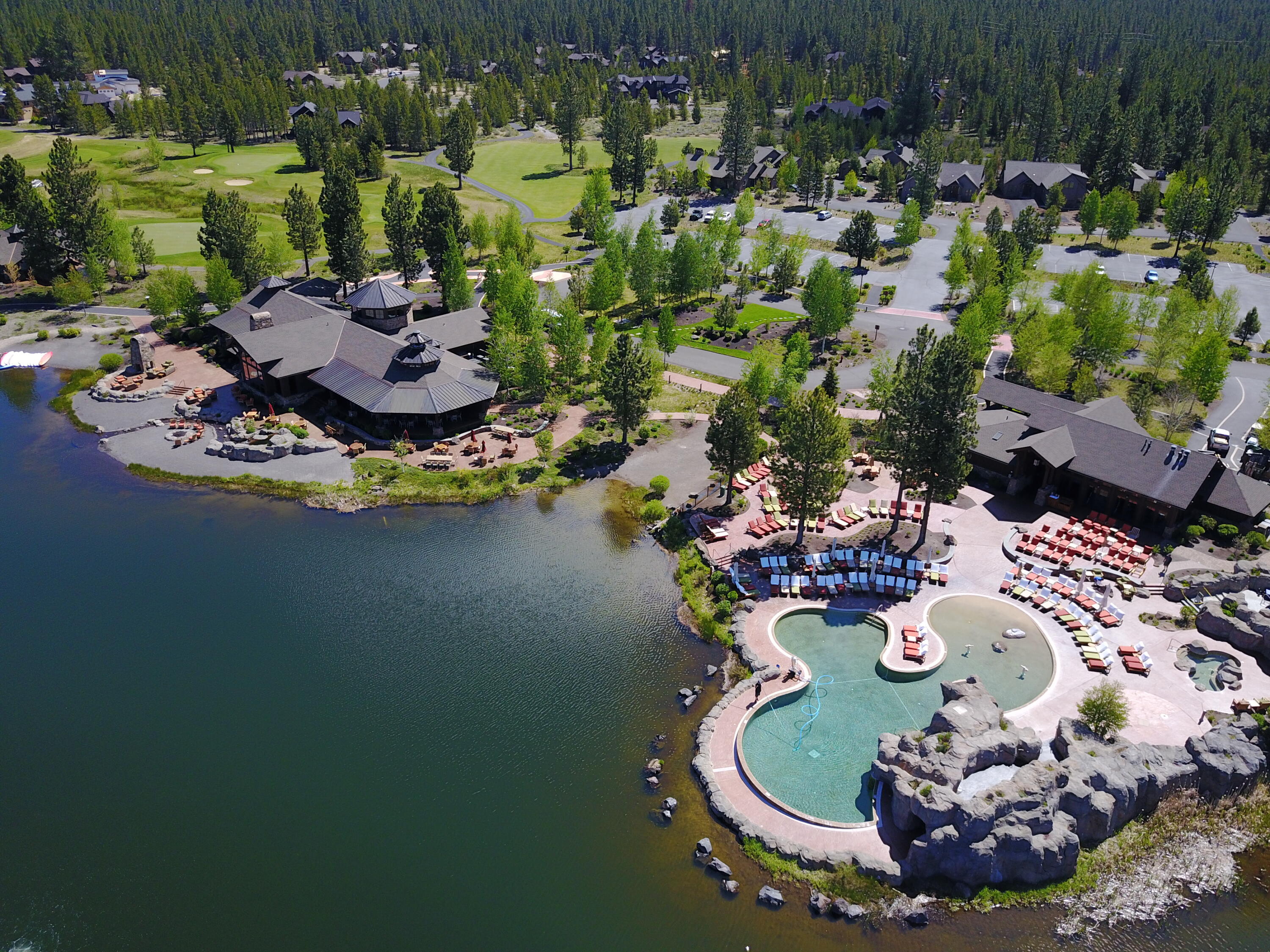 56347 Fireglass Loop, Unit 211 Bend, OR 97707 - Photo 16 of 33 Overlooking snow-capped Mt. Bachelor, the Caldera Springs Lake House & Pool and Fitness Building are the heart of this resort community. The buildings are a wonderful example of rustic ?Cascade Heritage? architecture featuring a ?bistro? restaurant, a full array of exercise, fitness, and aquatic facilities. Together these buildings provide the social focus and gathering place for families and friends during their stay at Caldera Springs. The architecture features timber structural elements, expansive ceilings with natural daylighting, copper roofs, and panoramic views to the surrounding landscape and lake. Covered terraces overlook man-made water features that start at the building and wind their way to the lake. Local natural boulders and stone veneer link the buildings to the site and the surrounding volcanic mountains.