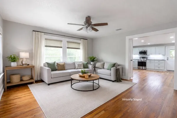 a living room with furniture and a wooden floor