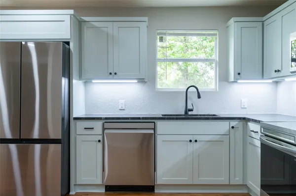 a kitchen with stainless steel appliances granite countertop a refrigerator sink and cabinets