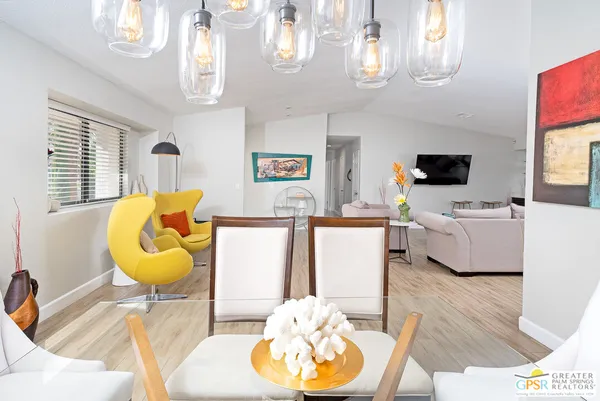 a living room with furniture a chandelier and a flat screen tv