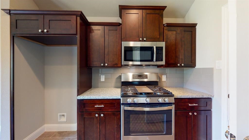 311 Mascot Street Houston, TX 77029 - Photo 12 of 23 a kitchen with stainless steel appliances granite countertop a stove microwave and refrigerator