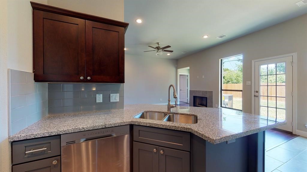 311 Mascot Street Houston, TX 77029 - Photo 14 of 23 a kitchen with stainless steel appliances granite countertop a sink a microwave cabinets and wooden floor