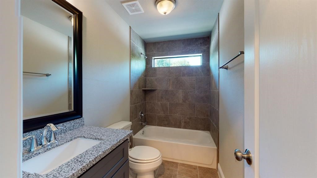311 Mascot Street Houston, TX 77029 - Photo 20 of 23 a bathroom with a granite countertop tub sink toilet and mirror