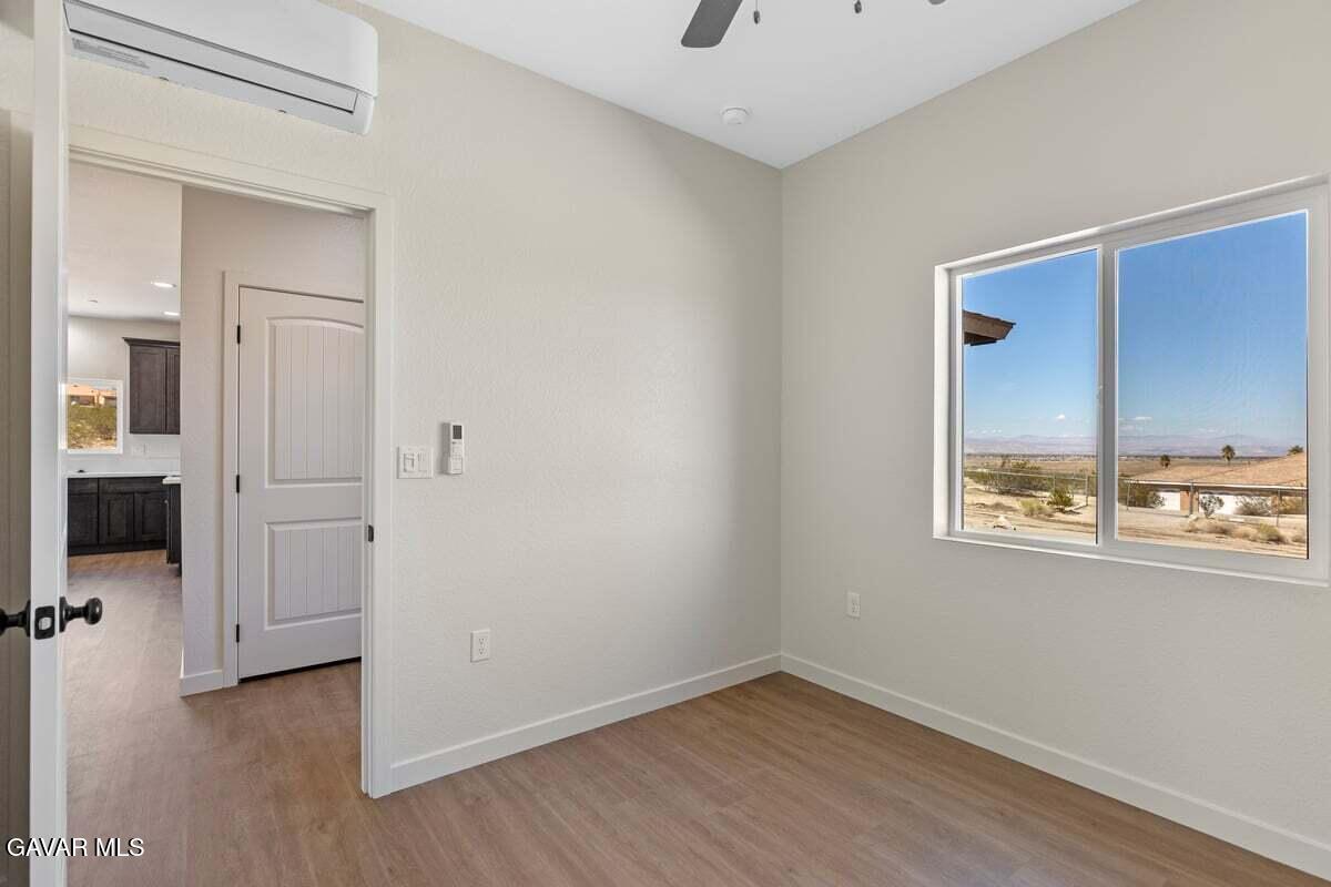 10654 Wilson Road California City, CA 93505 - Photo 14 of 36 an empty room with a window and wooden floor