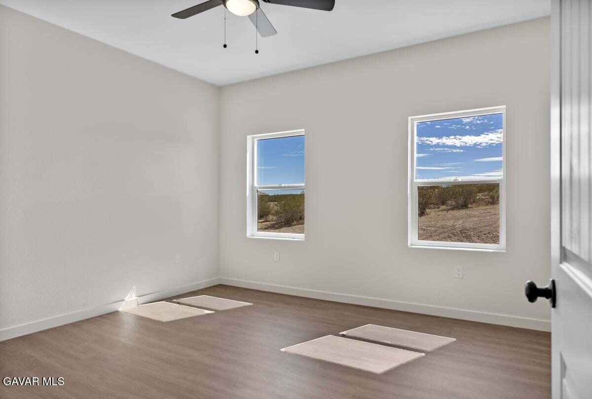 10654 Wilson Road California City, CA 93505 - Photo 17 of 36 a view of an empty room with a window and wooden floor