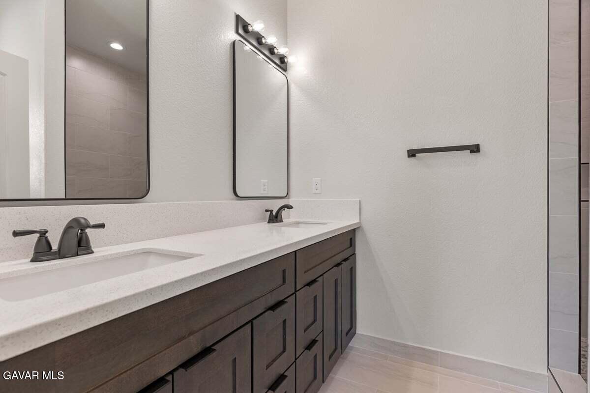 10654 Wilson Road California City, CA 93505 - Photo 21 of 36 a bathroom with a double vanity sink and a mirror