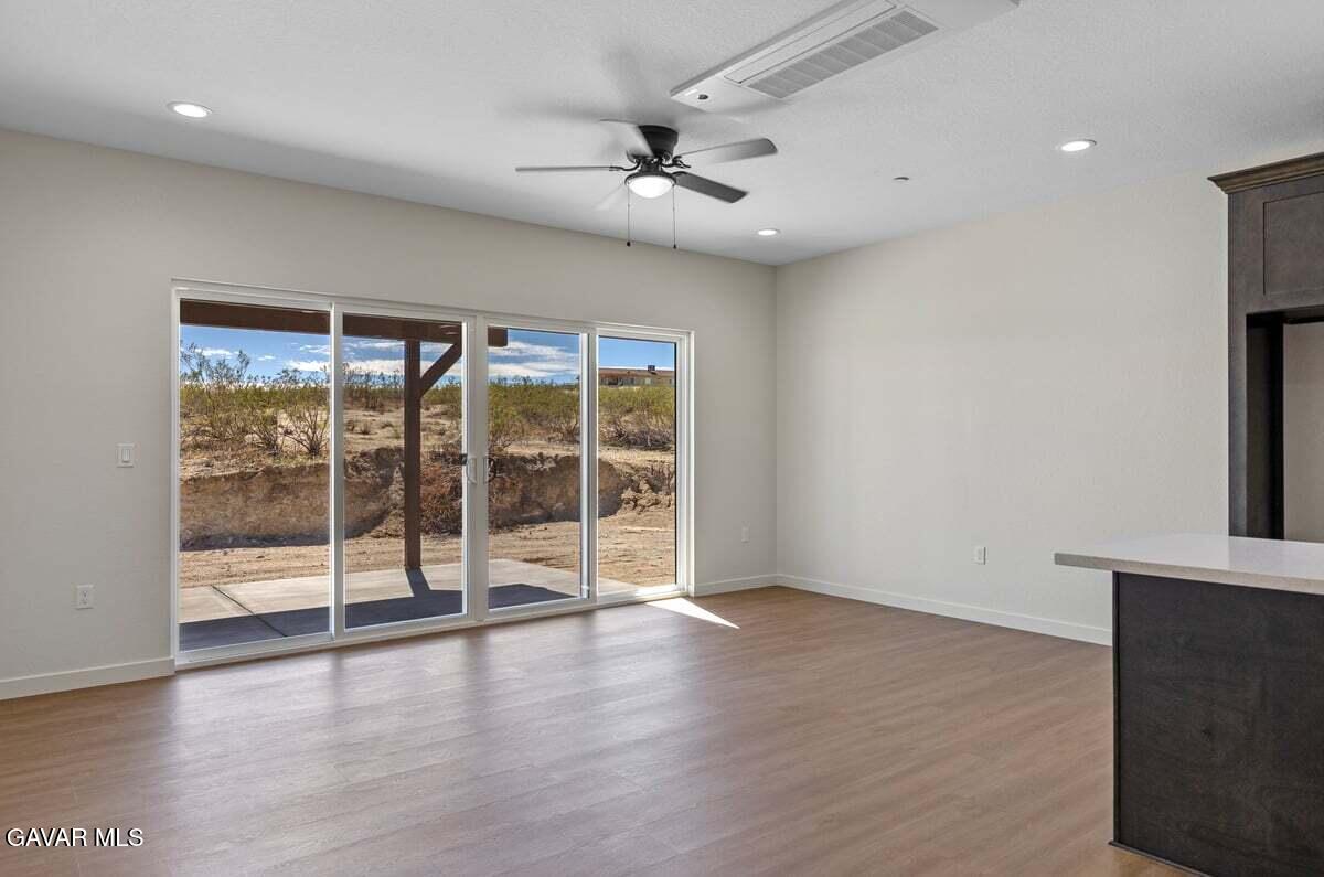 10654 Wilson Road California City, CA 93505 - Photo 8 of 36 an empty room with wooden floor and windows