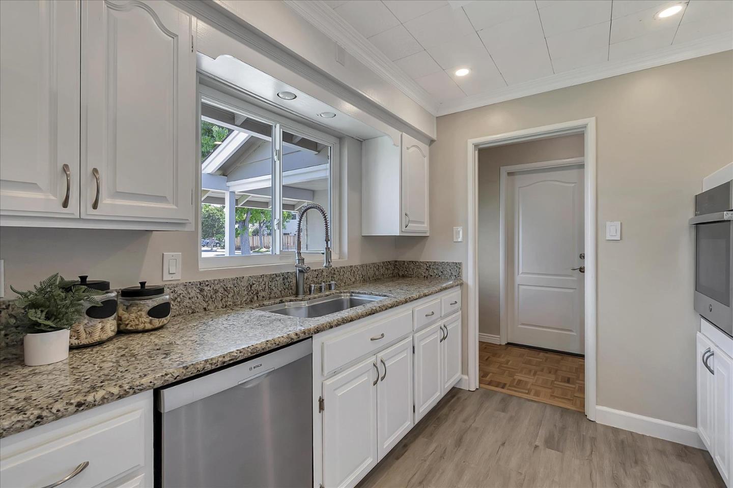 1963 Geneva Street San Jose, CA 95124 - Photo 10 of 35 a kitchen with granite countertop a sink stainless steel appliances white cabinets and wooden floor