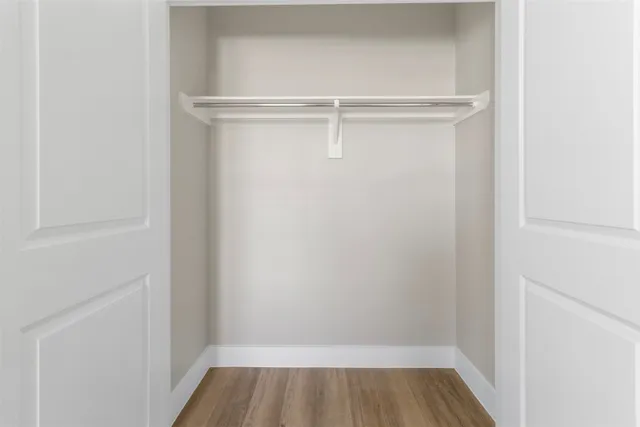 a view of walk in closet with wooden floor